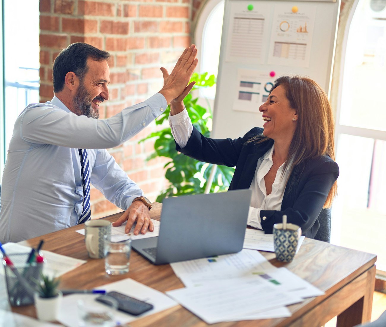 Two colleagues celebrating at their desk