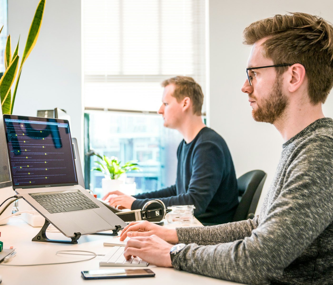 Two support engineers working at their desks